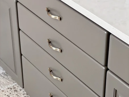 A modern gray vanity drawer front with updated hardware that has been repainted