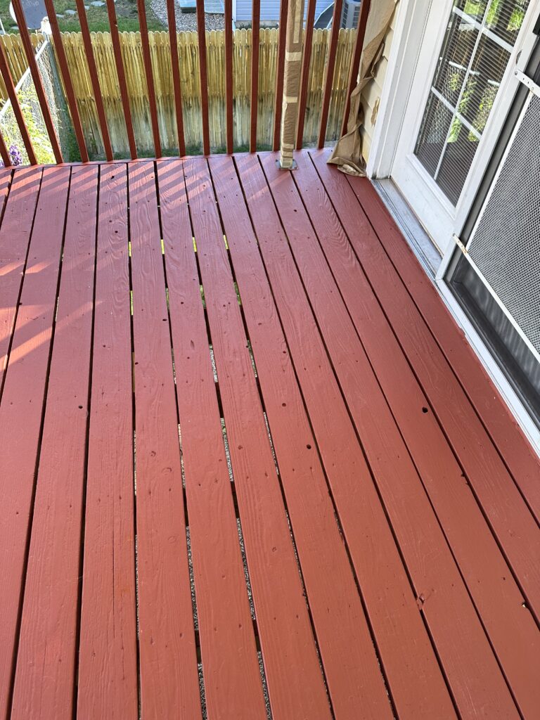 A red tinted stain on a wooden deck